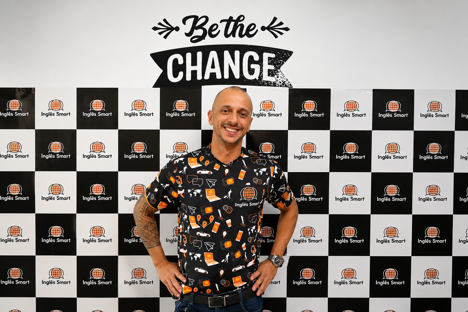 Fundador da Inglês Smart diante do painel da escola com o mote “Be the Change”